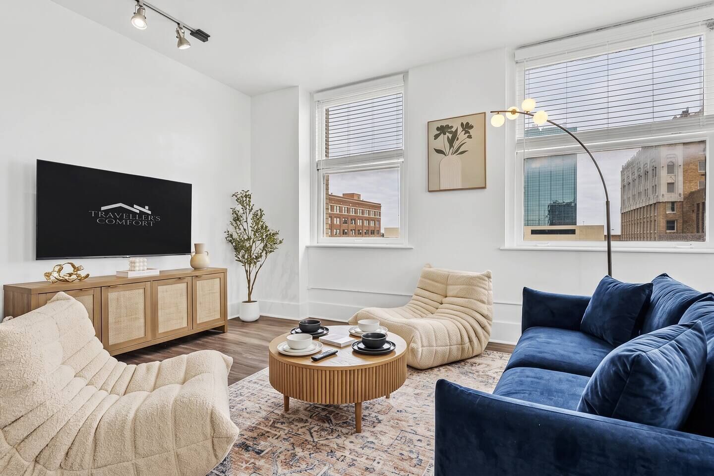 A modern living room with a flat-screen TV, a sofa, a chair, and a coffee table.