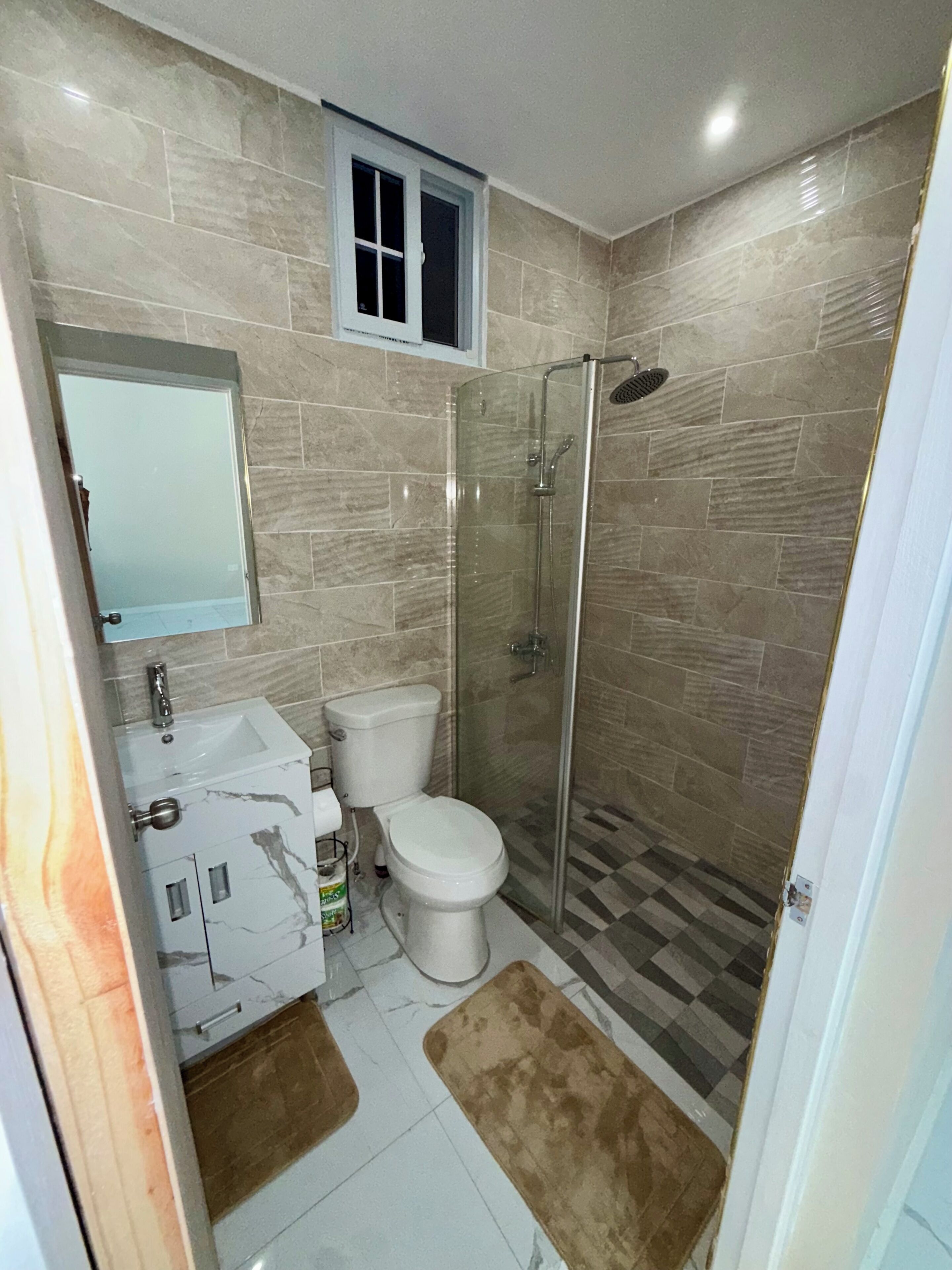 A bathroom with a toilet, sink, and shower.