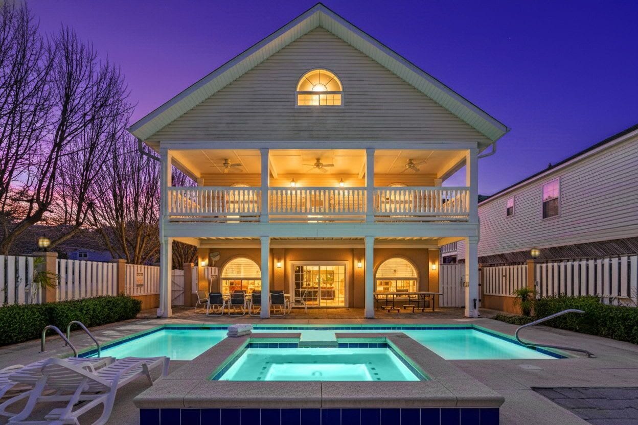 A two-story house with a swimming pool, a covered patio, and a balcony.