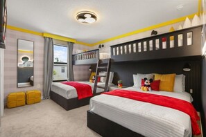 Een hotelkamer met stapelbedden, een groot raam en een spiegel.