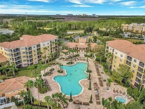 Een resort met meerdere gebouwen, een centraal gelegen zwembad en aangelegde tuinen.
