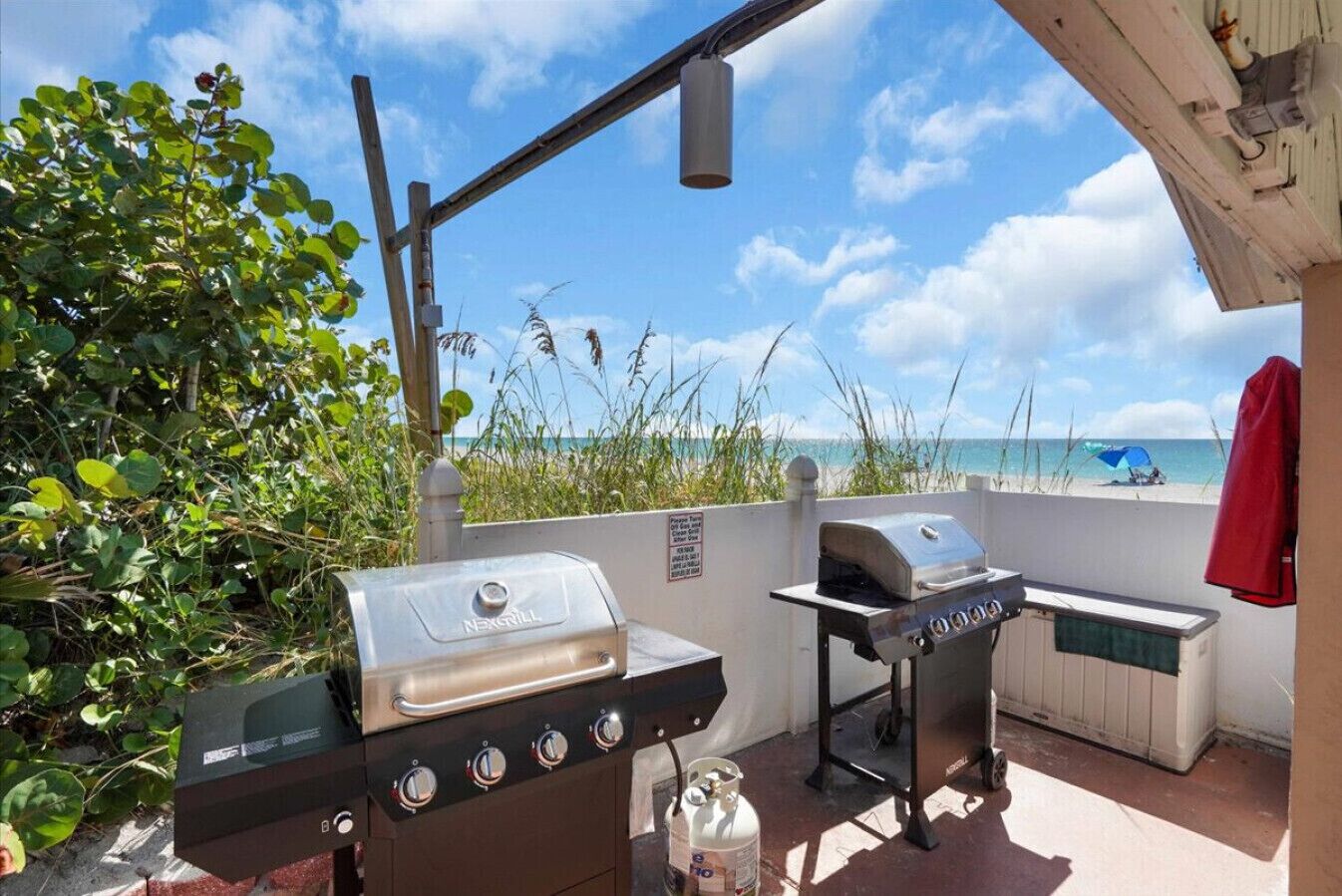 An outdoor grill area with a view of the beach.