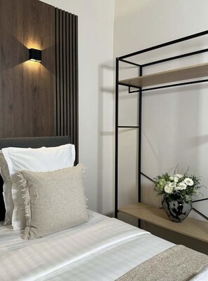 A modern bedroom with a bed, a wall-mounted shelf, and a nightstand. - Superb Appartment close to Marais by Melvane 4P (Paris)