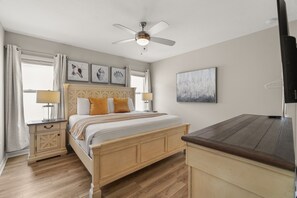 A bedroom with a wooden bed, two bedside tables with lamps, a ceiling fan, and artwork on the walls. - 6 BD/ 5.5 BA/ Solterra Resort (6043 BO) (Davenport)