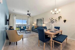A dining area with a wooden table, blue upholstered chairs, and a chandelier. - 2 BD/ 2 BA/ Storey Lake (3141-404 PC) (Kissimmee)
