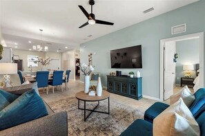 A modern living room with a dining area, a flat-screen TV, and a ceiling fan. - 2 BD/ 2 BA/ Storey Lake (3141-404 PC) (Kissimmee)