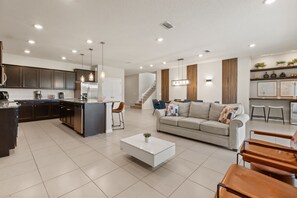 A modern kitchen with dark cabinets, a central island, and pendant lighting. - 10 BD/ 8 BA/ Windsor Island Resort (4321 LA) (Davenport)