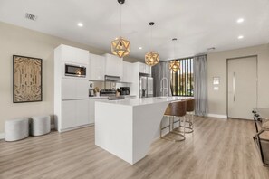 A modern kitchen with a central island, white cabinetry, and pendant lighting. - Brand New! 3 Bd/3.5 Ba/ Magic Village by Pininfarina - 5591 PW (Kissimmee)