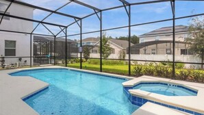 A swimming pool with a glass enclosure, a hot tub, and a view of residential buildings. - 8 BD/ 5 BA/ Bella Vida (4489 MD) (Kissimmee)