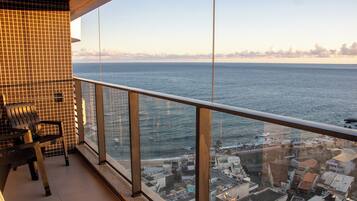 Un balcón con vista al mar y al paisaje urbano.