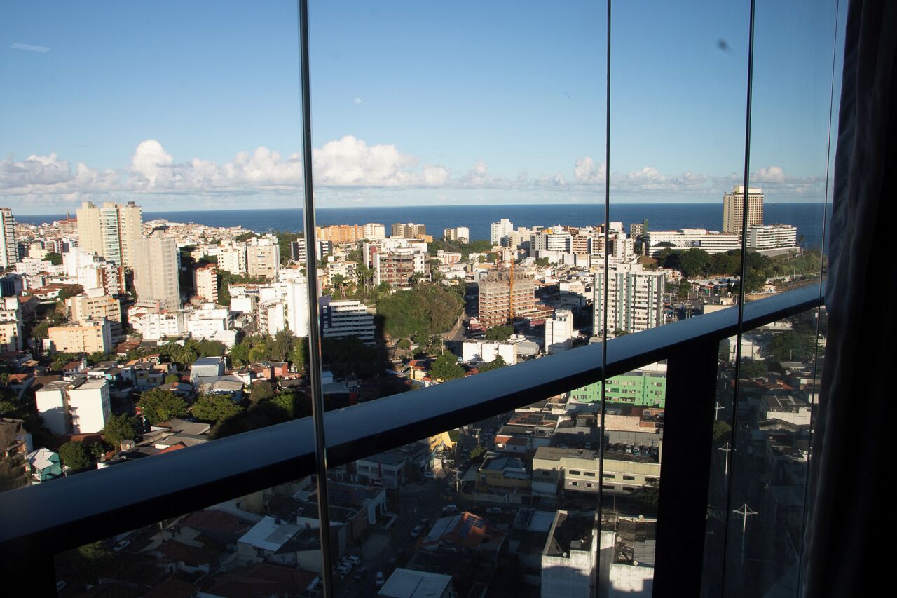 A cityscape with buildings and a body of water in the distance.
