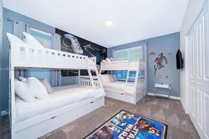 A bedroom with bunk beds, a Star Wars themed wall, and a Star Wars poster on the floor. - 5 BD/ 5 BA/ Storey Lake (4352 QS) (Kissimmee)