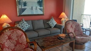 A living room with a sofa, two patterned chairs, a coffee table, and a painting on the wall. - Beach view unit  504 (Longboat Key)