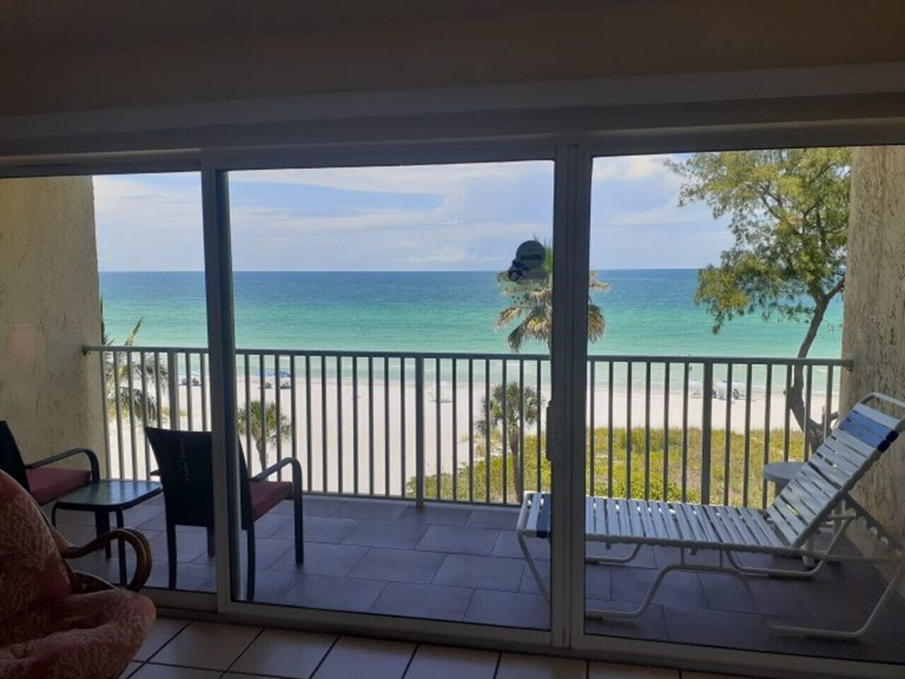 A balcony with a view of the beach and ocean.