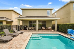 A residential backyard with a swimming pool, lounge chairs, and a barbecue area. - 5 BD/ 5 BA/ Encore Resort at Reunion (280 PC) (Kissimmee)