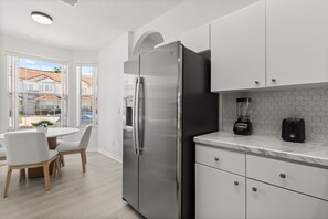 A modern kitchen with a stainless steel refrigerator, a blender, and a toaster on the counter. - 3 BD/ 2.5 BA/ Fiesta Key (1286 SB) (Kissimmee)
