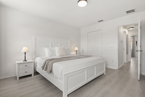 A bedroom with a white bed, two bedside tables with lamps, a wardrobe, and a door leading to another room. - 3 BD/ 2.5 BA/ Fiesta Key (1286 SB) (Kissimmee)