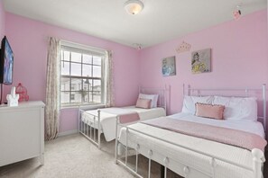 Ein zartrosa Schlafzimmer mit zwei Betten, einem Fenster und Bildern an den Wänden.