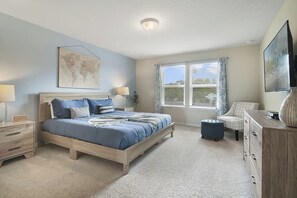 A bedroom with a bed, bedside tables, a dresser, a television, and a window with curtains. - 5 BD/ 4.5 BA/ Windsor Island (131 JW) (Davenport)
