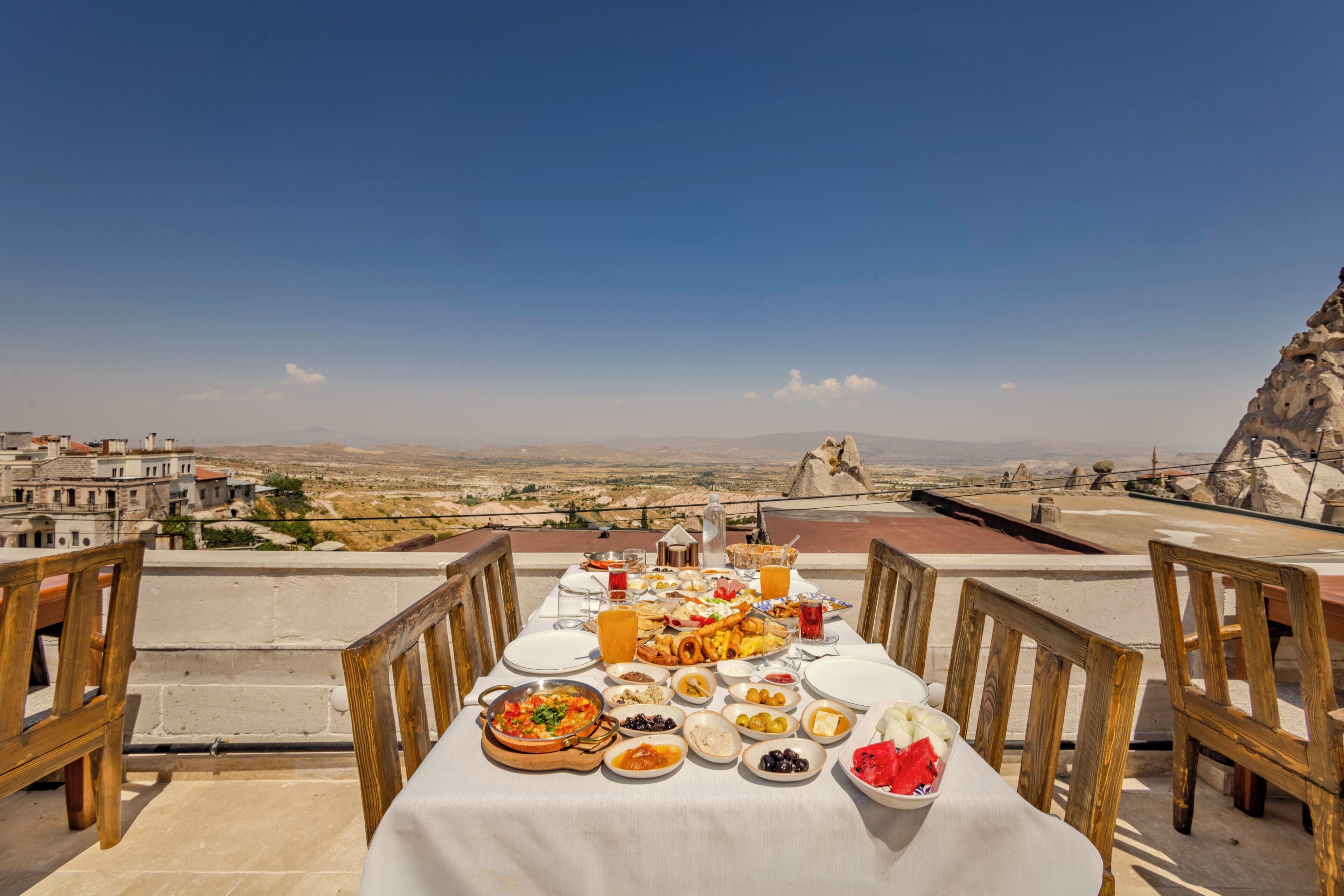 A dining table set with various dishes and a view of a mountainous landscape.