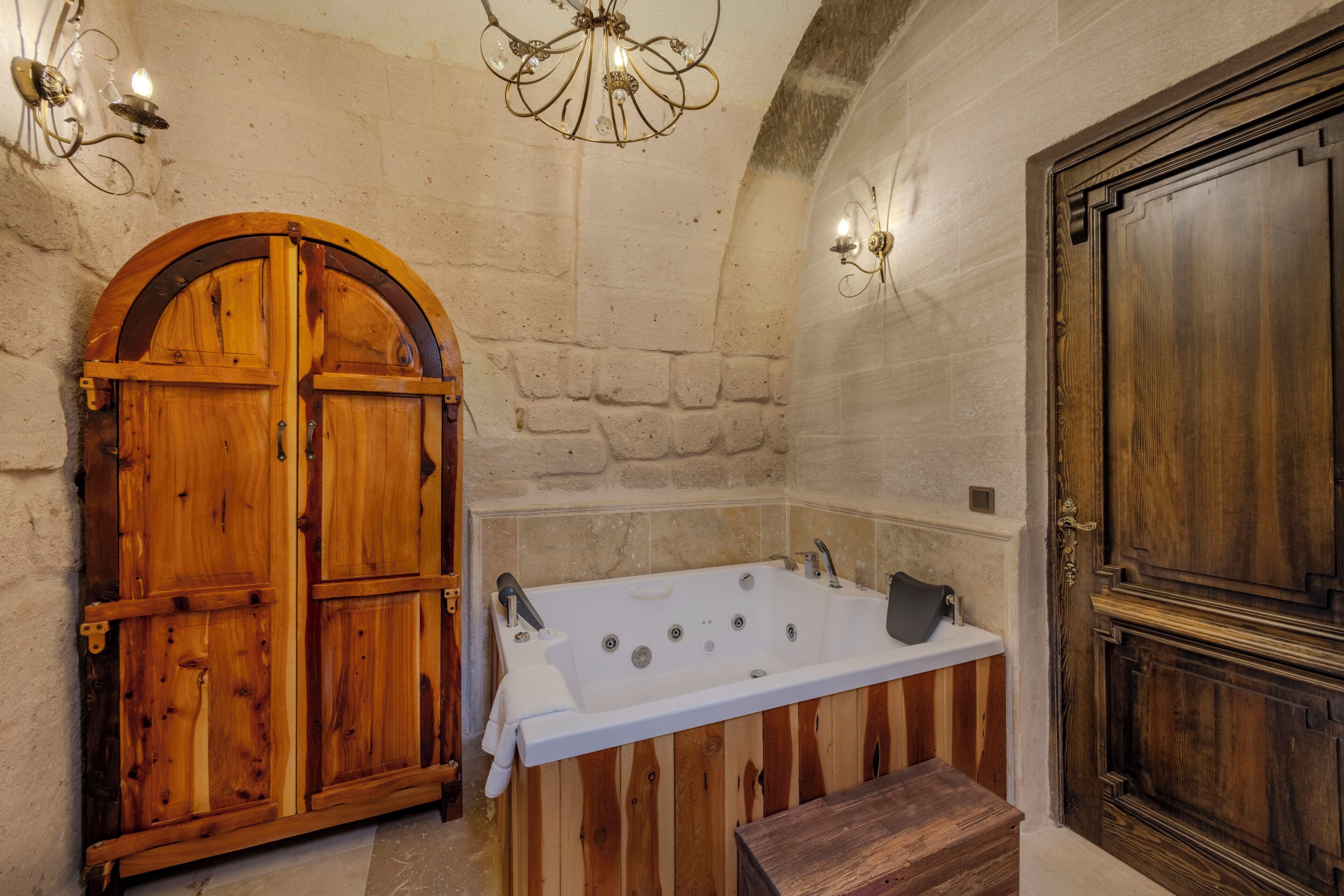 Un baño con puerta de madera, bañera y zona de ducha.