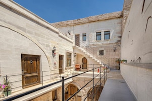Un estrecho callejón con edificios de piedra, una puerta de madera y una escalera que conduce a un nivel superior.