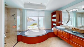 Ein modernes Badezimmer mit einer großen Badewanne, einer begehbaren Dusche und einem Waschtisch mit großem Spiegel.
