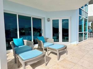 Ein Balkon mit Korbmöbeln und Glastüren.