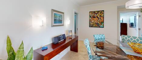 Una sala moderna con una consola de madera, una mesa de centro de cristal y sillas con estampado.