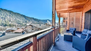 A wooden balcony with a view of a mountainous landscape and buildings below. - 100m from ski slopes, 2nd floor, terrace, tv, 78m², Les Gets (Les Gets)