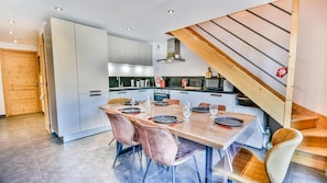 A modern kitchen with a dining area, wooden staircase, and a view of the outside. - 100m from ski slopes, 2nd floor, terrace, tv, 78m², Les Gets (Les Gets)