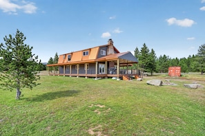 Une maison à deux étages avec un porche et une cheminée.