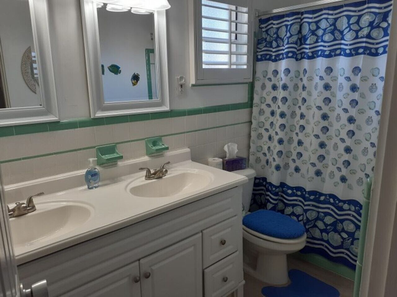 A bathroom with two sinks, a toilet, and a shower curtain.