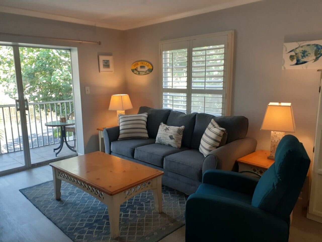 A living room with a sofa, armchair, coffee table, and two lamps.