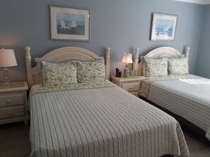 A bedroom with two beds, each with a headboard and a bedside table with a lamp. - Luxury at its best at Turtle Crawl Resort (Longboat Key)