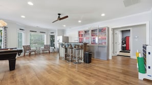 A spacious living room with a pool table, bar stools, and a kitchen area with a refrigerator and cabinets. - Point of View by Avantstay Private Dock + Kayaks + Hot Tub Lakefront Game Room + Cabana + BBQ (Mooresville)