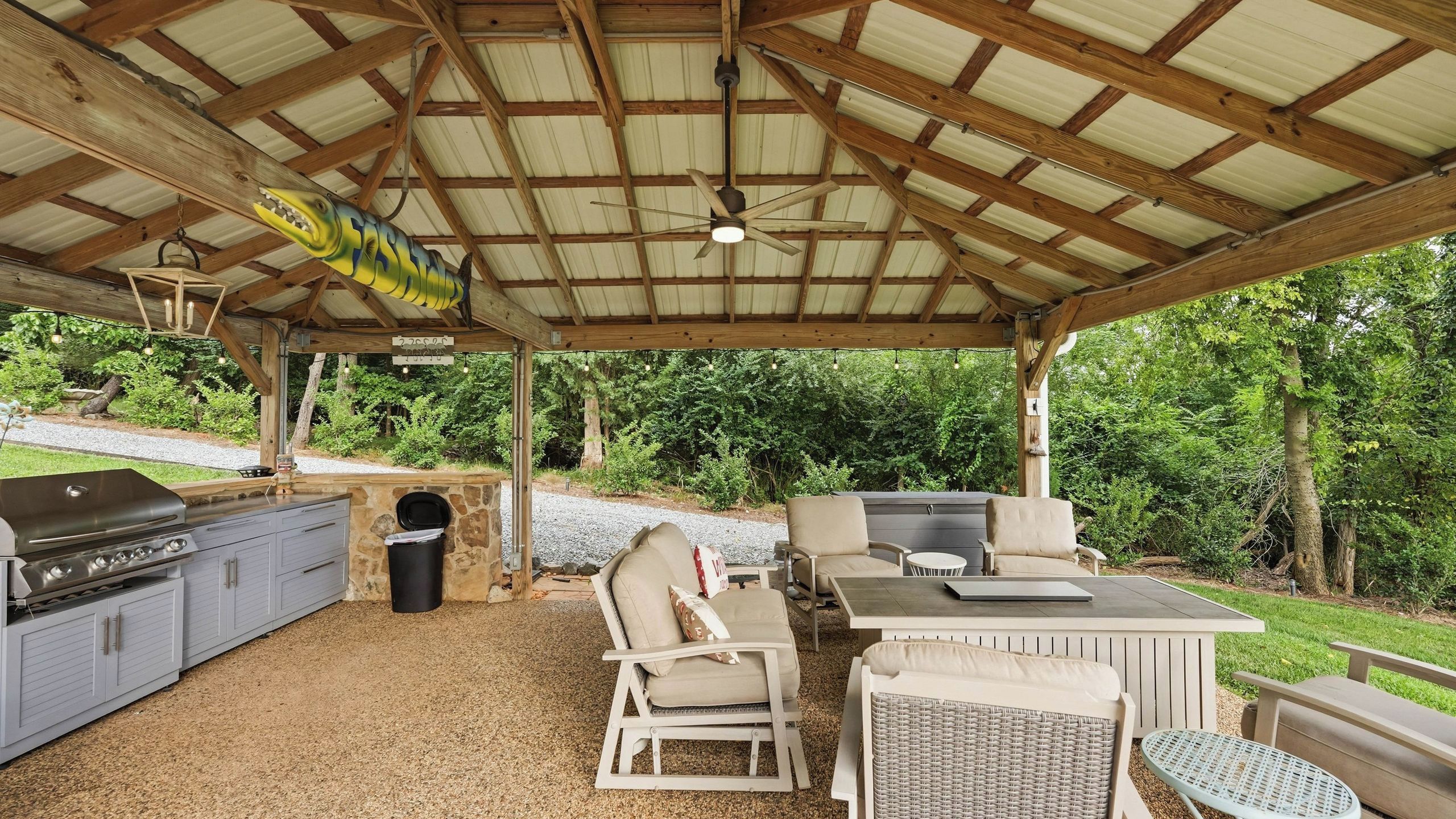 Une terrasse extérieure équipée d’un barbecue, de sièges et d’un espace abrité.