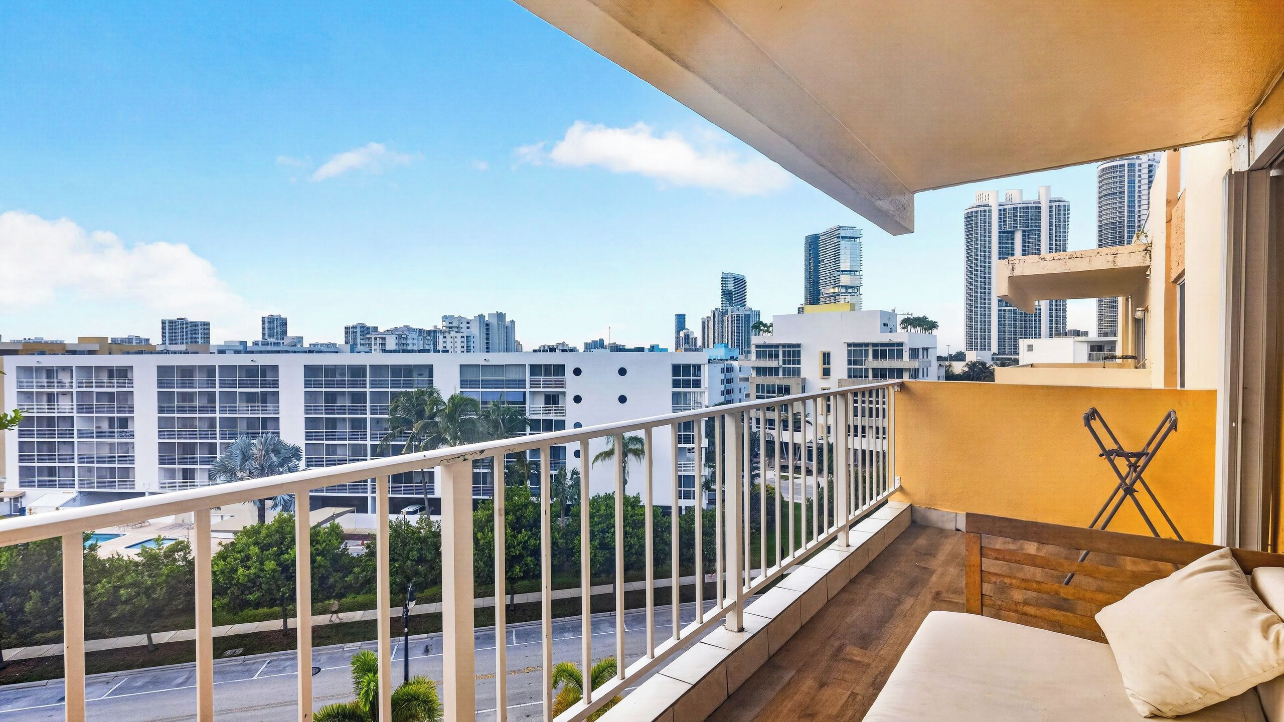 Uma varanda com vista para a cidade, um sofá e uma pequena mesa.