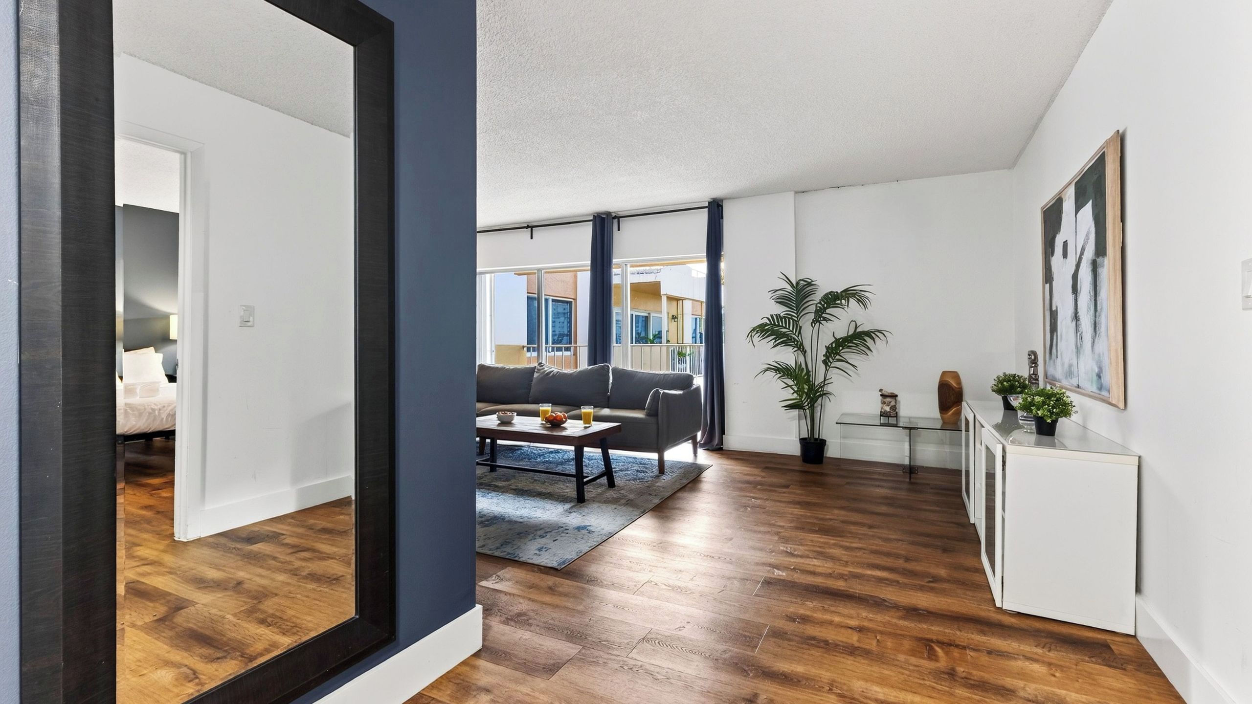 A modern living room with a sofa, coffee table, and a view of the outside.