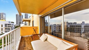 A balcony with a sofa, a small table, and a chair. - Isle Vista by Avantstay Sunny Isles Condo Shared Pool + Private Balcony Near Beaches (Sunny Isles Beach)