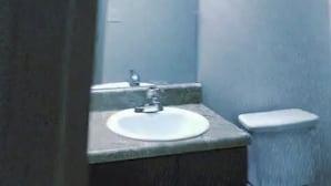 Kylpyhuone, jossa on pesuallas, peili ja wc.