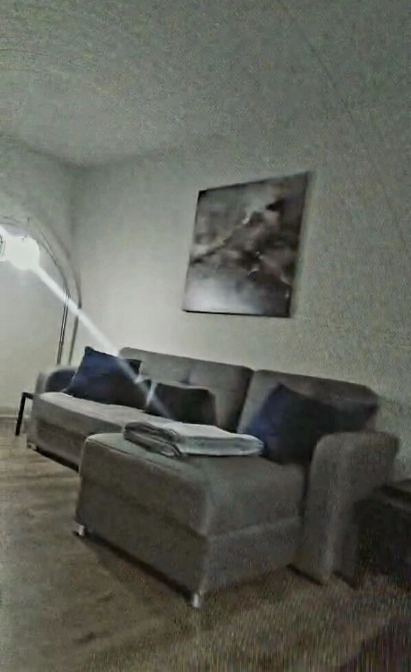 A living room with a sofa, a coffee table, and a lamp.
