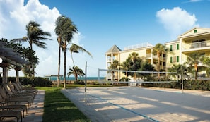 A beachside hotel with a volleyball court, palm trees, and a view of the ocean. - Spacious Oceanside 2BR 2BA Condo w/Heated Infinity Pool - Hyatt Windward Pointe (Key West)