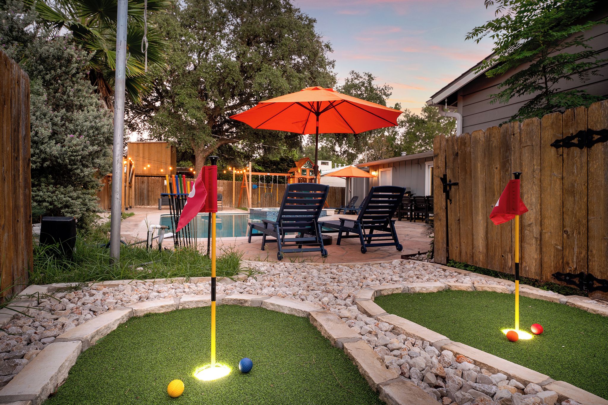 Un giardino sul retro con piscina, area salotto esterna e campo da mini-golf.
