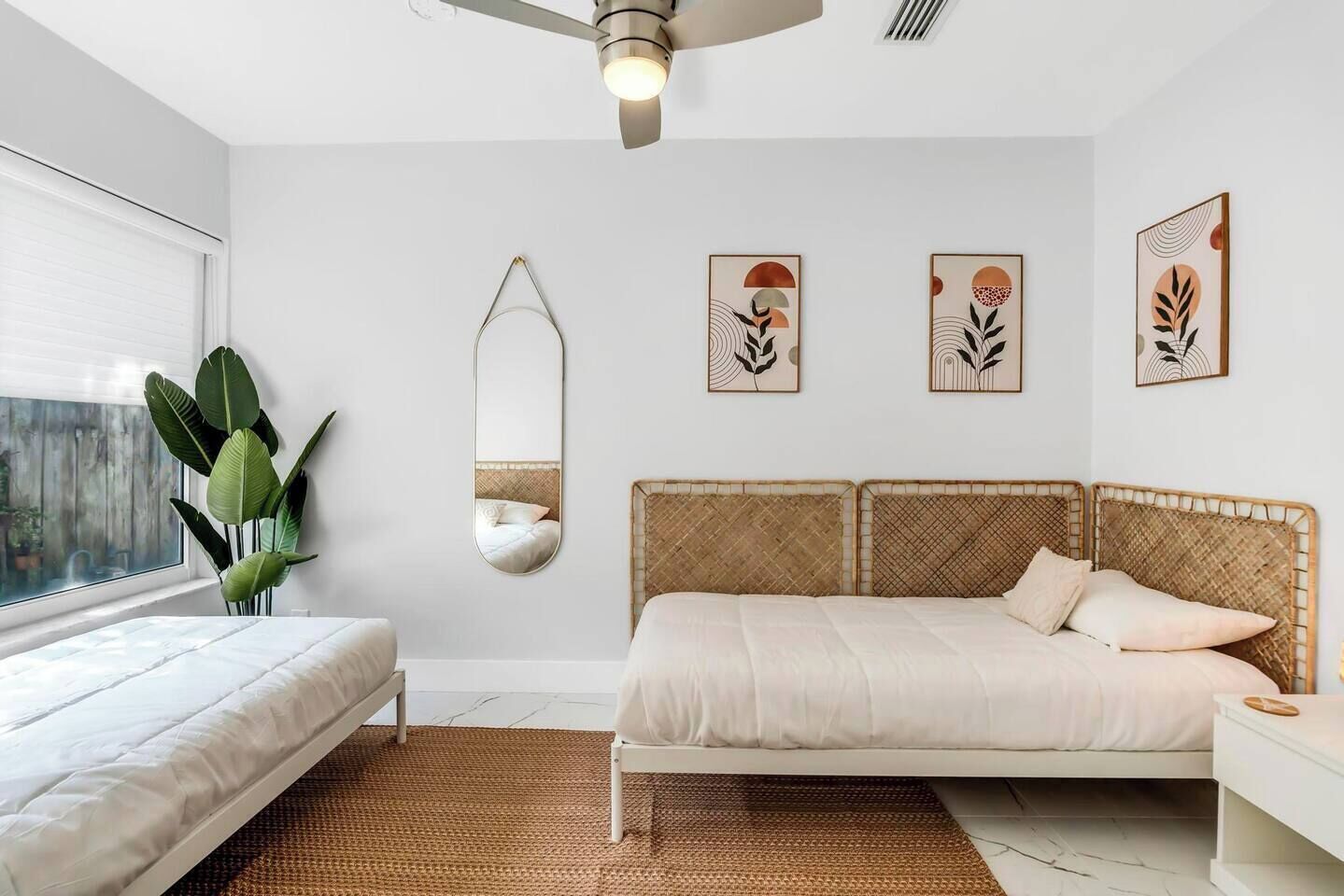 A bedroom with a bed, a bedside table, a mirror, and wall art.