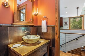 A bathroom with a large mirror, a vessel sink, and a towel rack. - Booth Creek Lodge | 4BR East Vail Retreat, Sleeps 8 (Vail)