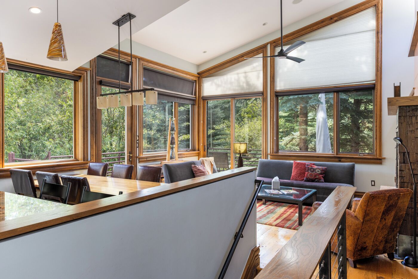 Ein modernes Interieur mit Essbereich, Sitzgelegenheiten und großen Fenstern mit Blick ins Freie.