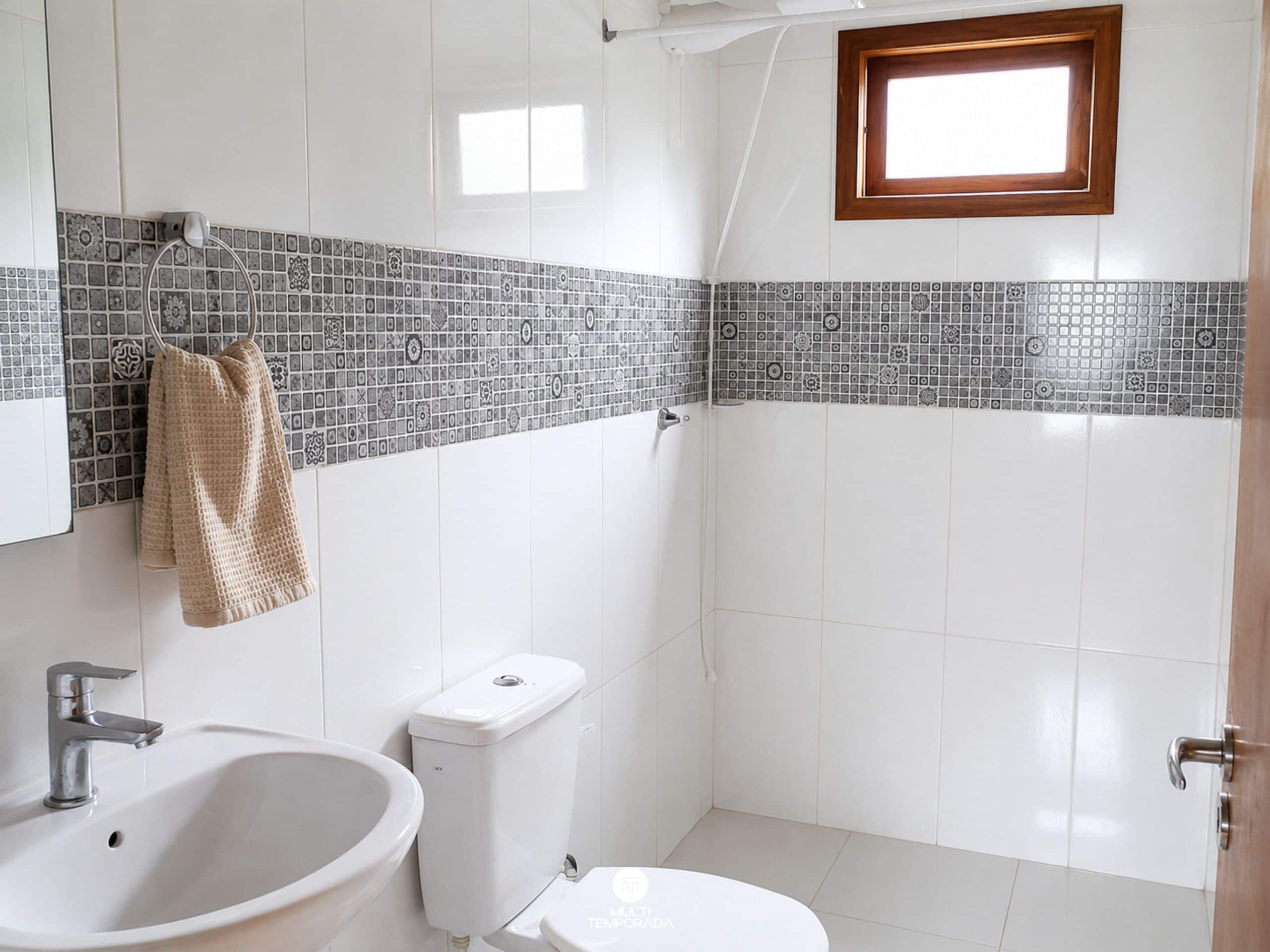 A bathroom with a sink, toilet, and shower area.