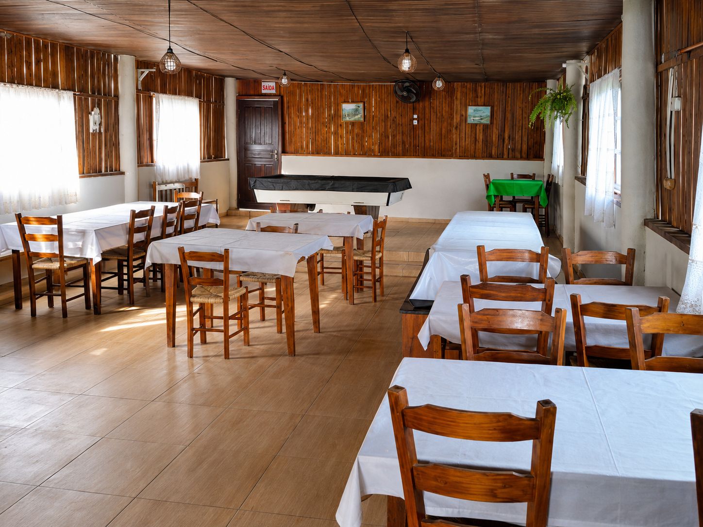 Un restaurante con paredes y mesas de madera listas para comer.