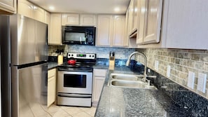 A kitchen with stainless steel appliances, a microwave, a stove, and a sink. - Welcome to our beachfront Maui 'Ohana! - Steps to the beach! (Lahaina)